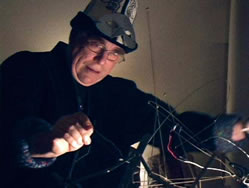 Daniel Goode performing on a musical wire sculpture.