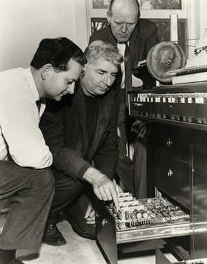 Le studio de musique électronique EMS vers 1964: István Anhalt, Hugh Le Caine et Helmuth Blume examinant le magnétophone à application spéciale, également nommé multipiste
